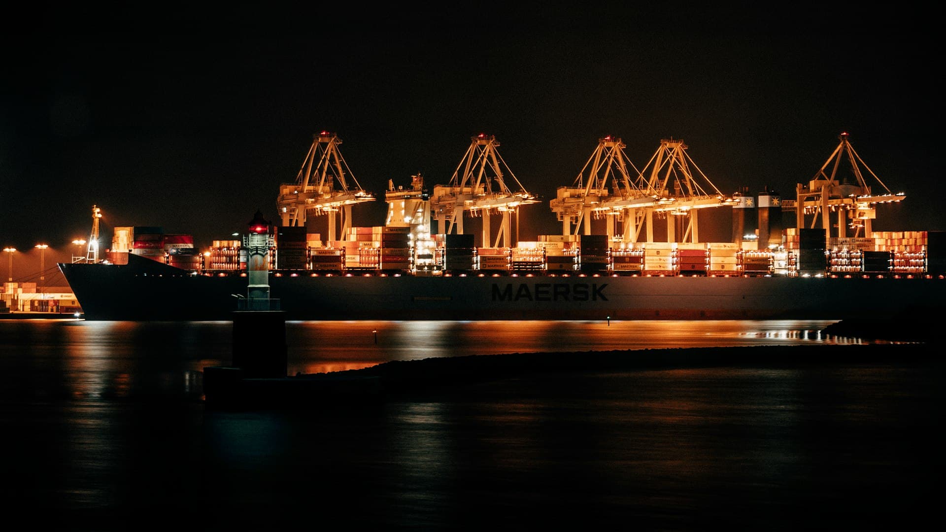 Cargo ship at a lit dock during the night shift